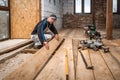 Woodworker, carpenter makes wooden floor using miter saw