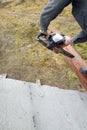 woodworker with a chainsaw makes drank on a wooden beam construction of houses