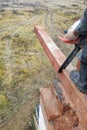 woodworker with a chainsaw makes drank on a wooden beam construction of houses