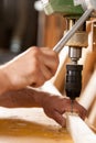 Woodworker drilling a plank with machinery