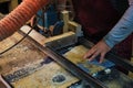 A woodworker feeds lumber. It underscores the harmony of man and machine in creation.
