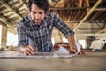 Woodworker going over design plans on a workshop bench Royalty Free Stock Photo