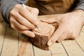 Woodworker hands sketching on wood billet