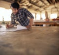 Woodworker leaning on a workshop bench reading furniture plans Royalty Free Stock Photo