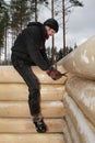 Woodworker makes marks on a log surface using scriber tool