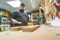 Woodworking artistry concept. Adult craftsman preparing wooden planks to be used. Low angle indoor shot. Carpentry