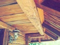 Woodworking for construction and roofing. Wooden beam and roof in a traditional peasant house. Metal lantern on the wall