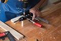 Woodworking entrepreneurs are using a drill through the wood holes to assemble and build wooden tables for customers