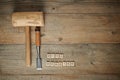 Woodworking word with mallet and chisel on wooden workbench, top