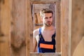 Woodworks concept. Scaffolding and frameworks. Planning construction. Man builder in work clothes. View through Royalty Free Stock Photo