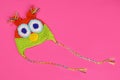 Wool knitted handmade hat for children in the form of an owl on a pink background. Copy space for text Royalty Free Stock Photo