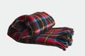 Wool,plaid scotch blanket,rolled and isolated on white surface.