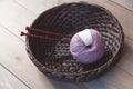 Wool yarn and knitting needles in the basket on the wooden background