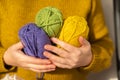 Wool yarn in yellow, purple and green. Knitting hobby.Skeins of yarn of various colors in hands in a in a mustard wool Royalty Free Stock Photo