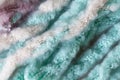 Woolen fluffy threads or tassels from scarf, macro. Soft pastel colors merino wool backdrop, closeup. Autumn and winter flat lay.