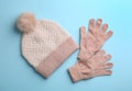 Woolen gloves and hat on light blue background, flat lay Royalty Free Stock Photo