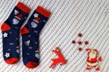 Woolen socks with Christmas pattern, Santa Claus, Saint Nicholas, and New Year s decorations lie on white background. Christmas