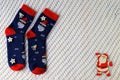 Woolen socks with Christmas pattern, Santa Claus, Saint Nicholas, and New Year s decorations lie on white background. Christmas