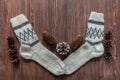 Woolen socks for cold season and pine cones on brown vintage wood surface Royalty Free Stock Photo