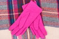 Woolen womanly pink gloves and colorful scarf, clothing for autumn or winter concept