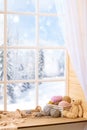 Woolen yarn and fabric on the window sill. Beautiful view outside the window - winter landscape and snow