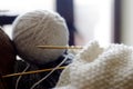 Woolen yarn for knitting. Close-up shots of white ball of natural wool yarn and knitting needles Royalty Free Stock Photo