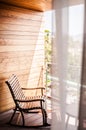 Woooden rocking chair behind curtain at balcony with evening sun Royalty Free Stock Photo