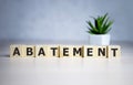 The word ABATEMENT written on wooden cubes on a blue background Royalty Free Stock Photo