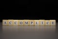 The word ACCOMPLICE written on wooden cubes, isolated on a black background Royalty Free Stock Photo