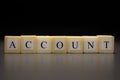 The word ACCOUNT written on wooden cubes, isolated on a black background Royalty Free Stock Photo
