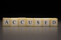 The word ACCUSED written on wooden cubes, isolated on a black background Royalty Free Stock Photo