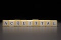 The word ACQUITTAL written on wooden cubes, isolated on a black background Royalty Free Stock Photo