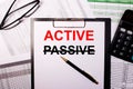 The word ACTIVE is written on a white sheet of paper, near the glasses and the calculator