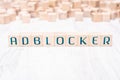 The Word Adblocker Formed By Wooden Blocks On A White Table