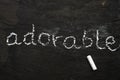The word adorable written with chalk on black stone. Royalty Free Stock Photo