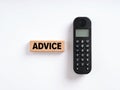 The word advice on wooden block with a wireless phone. Online support service, assistance or help Royalty Free Stock Photo