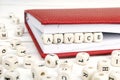 Word Advice written in wooden blocks in red notebook on white wooden table.