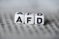 Word AFD formed by wood alphabet blocks on newspaper german party politics