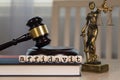 Word AFFIDAVIT composed of wooden dices. Wooden gavel and statue of Themis in the background