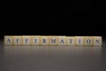 The word AFFIRMATION written on wooden cubes isolated on a black background