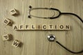 Word affliction from wooden blocks with stethoscope