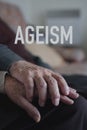 Word ageism and old man and woman holding hands Royalty Free Stock Photo