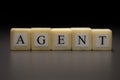The word AGENT written on wooden cubes isolated on a black background Royalty Free Stock Photo