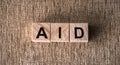 The word AID written in wooden blocks letters