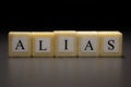 The word ALIAS written on wooden cubes isolated on a black background Royalty Free Stock Photo