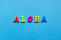 word aloha on blue paper background.