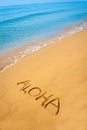 Word Aloha written in sandy on tropical beach