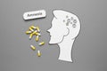 Word Amnesia, pills and human head cutout with metal nuts as brain on grey background, flat lay