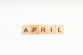 Word APRIL made of wooden blocks on white background. Month of year