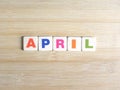 Word April on wood background